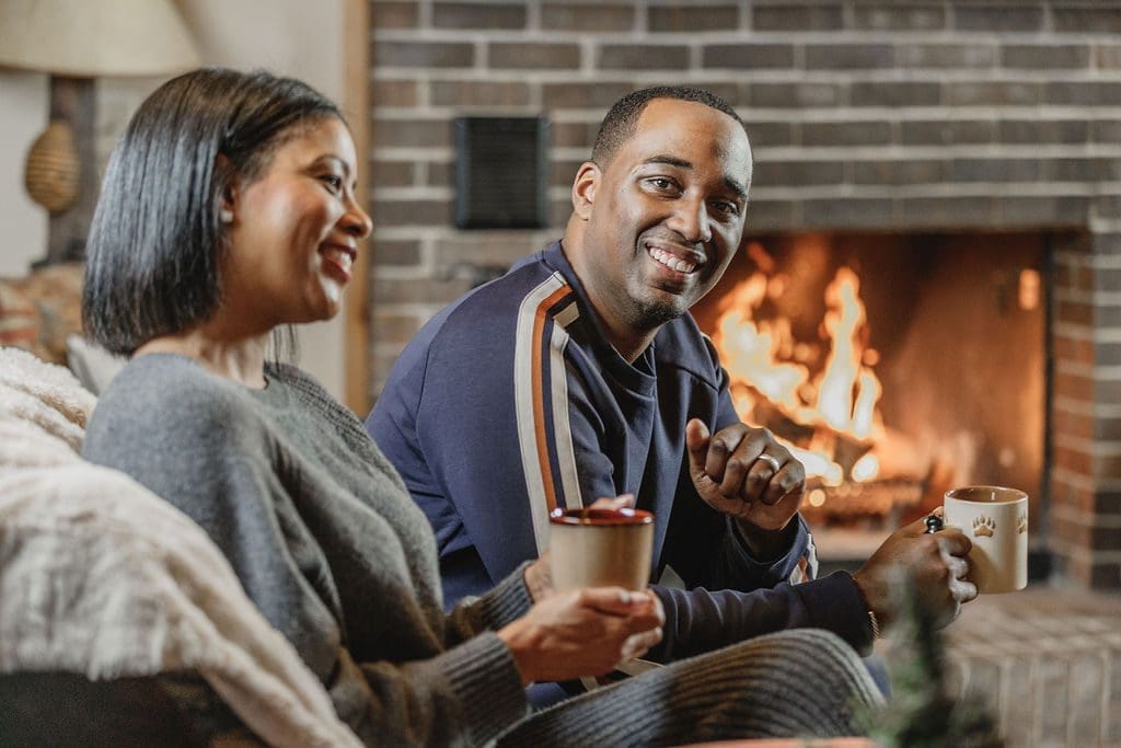 friends enjoying hot cocoa by a fire